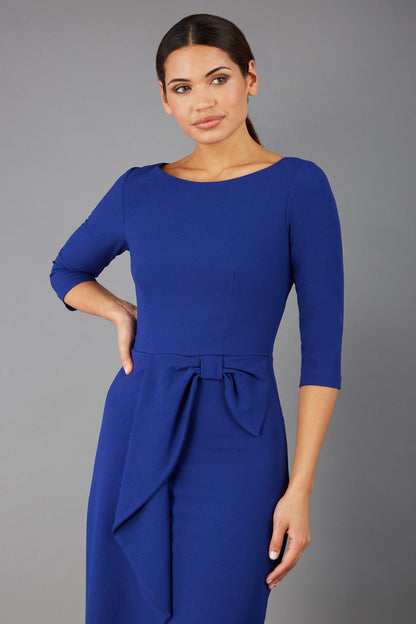 model is wearing diva catwalk jacky dress with rounded neckline 3/4 sleeve and bow detail on the waist in oxford blue front view (Oxford Blue)