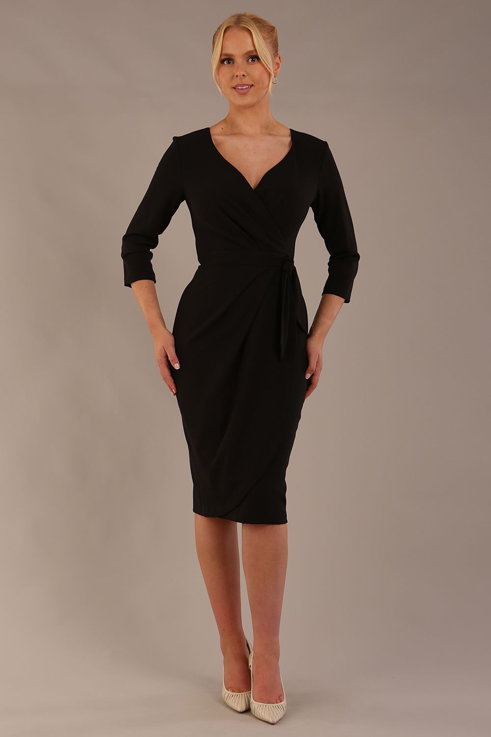 model wearing diva catwalk elan elegant black dress with 3 4 sleeves with a tie detail and asymmetrical closing front (Black)