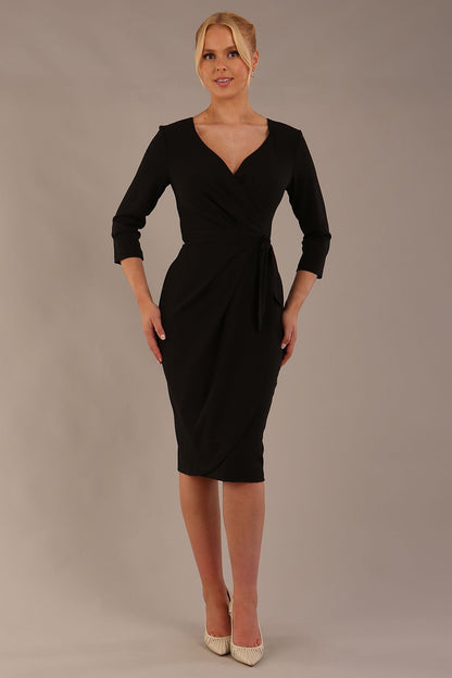 model wearing diva catwalk elan elegant black dress with 3 4 sleeves with a tie detail and asymmetrical closing front (Black)
