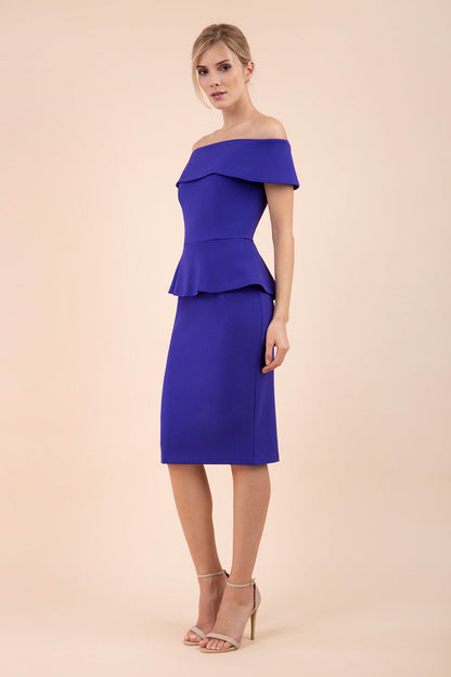blonde model wearing diva catwalk peplum summer pencil dress in indigo blue colour off shoulder bardot neckline front