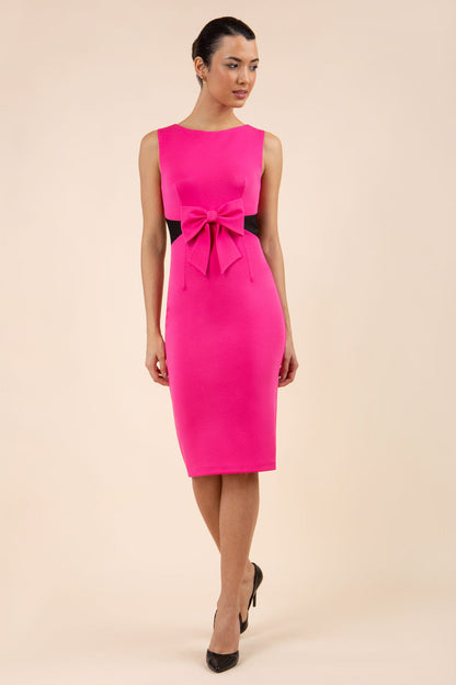 blonde model wearing Diva Catwalk Pencil sleeveless dress with rounded neckline and bow detail at the front with a contrasting black band in hibiscus pink back