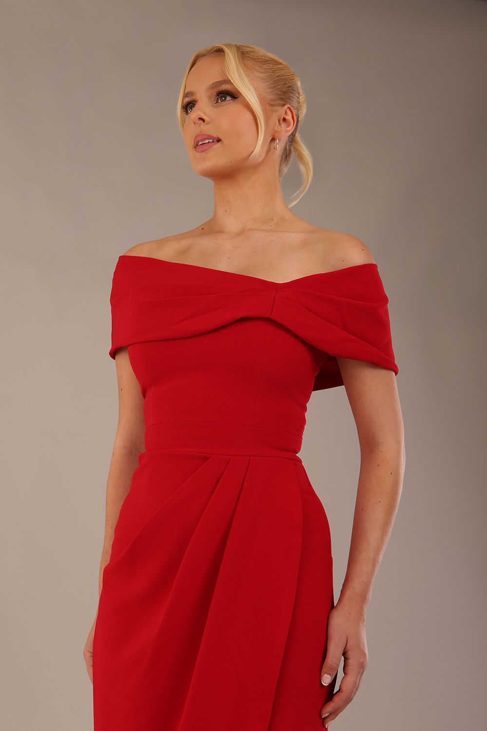 model wearing diva catwalk vegas calf length midaxi dress with wide bardot neckline and open shoulders with a large opening at the front of the skirt with pleating coming down long skirt front in scarlet red (Scarlet Red)