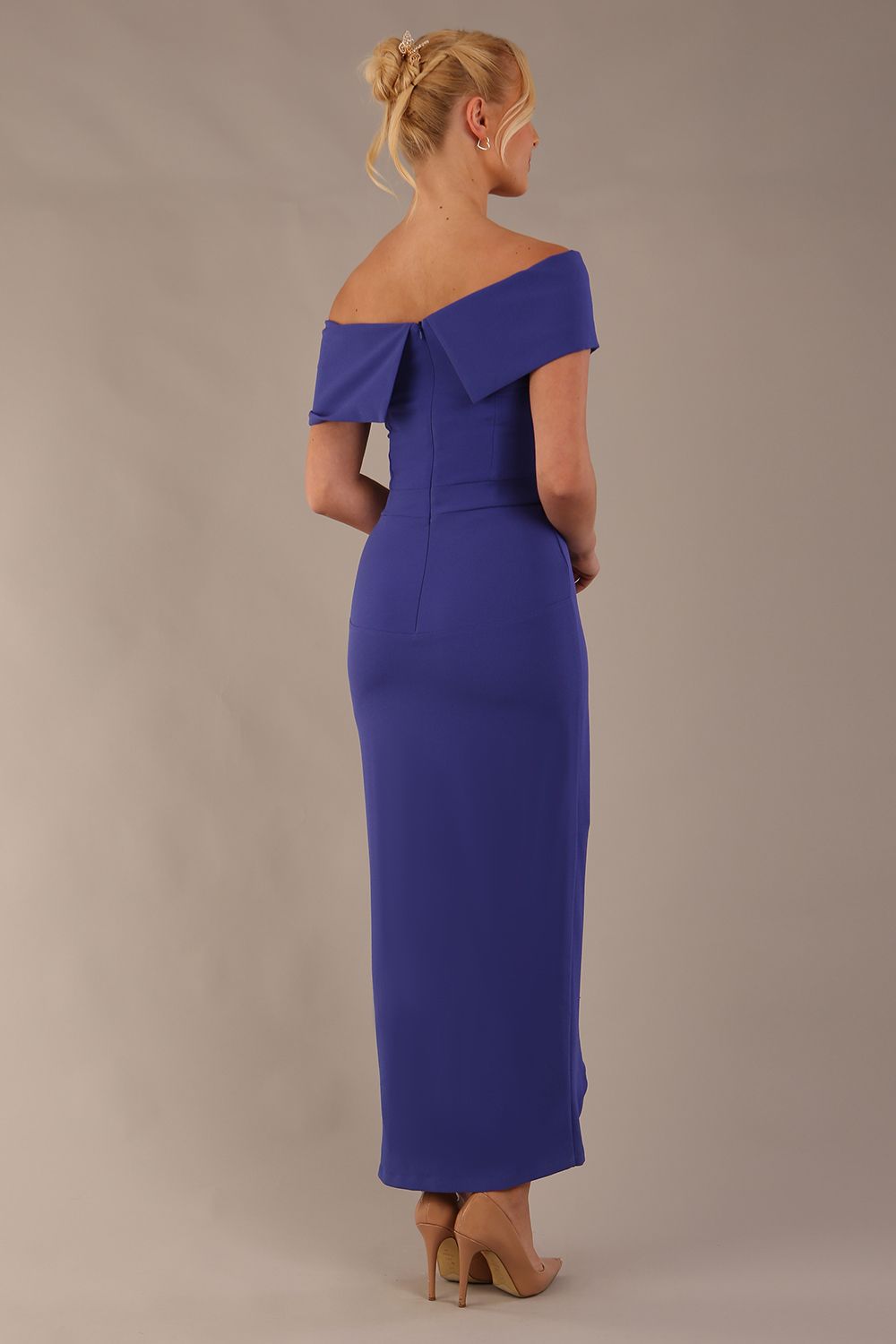 model wearing diva catwalk vegas calf length spectrum indigo midaxi dress with wide bardot neckline and open shoulders with a large opening at the front of the skirt with pleating coming down long skirt front (Spectrum Indigo)