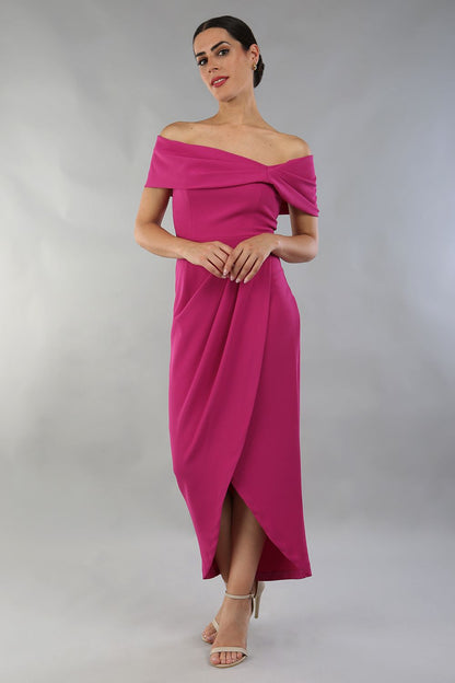 model wearing diva catwalk vegas calf length magenta midaxi dress with wide bardot neckline and open shoulders with a large opening at the front of the skirt with pleating coming down long skirt front (Magenta)
