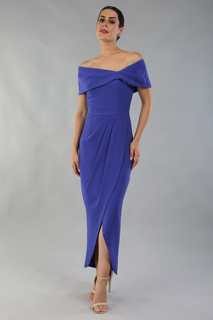 model wearing diva catwalk vegas calf length spectrum indigo midaxi dress with wide bardot neckline and open shoulders with a large opening at the front of the skirt with pleating coming down long skirt front (Spectrum Indigo)