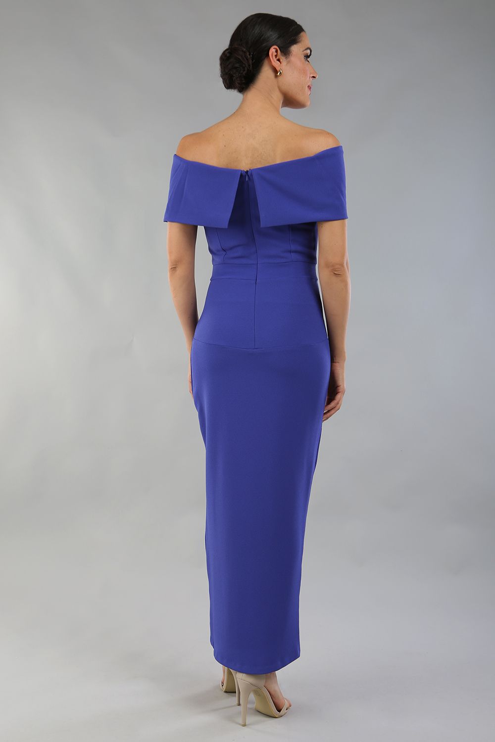 model wearing diva catwalk vegas calf length spectrum indigo midaxi dress with wide bardot neckline and open shoulders with a large opening at the front of the skirt with pleating coming down long skirt front (Spectrum Indigo)