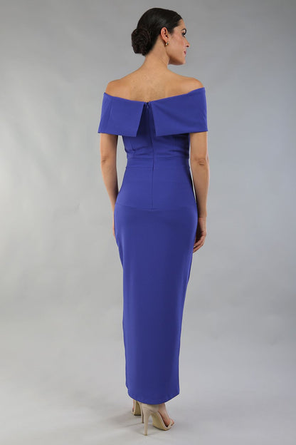 model wearing diva catwalk vegas calf length spectrum indigo midaxi dress with wide bardot neckline and open shoulders with a large opening at the front of the skirt with pleating coming down long skirt front (Spectrum Indigo)