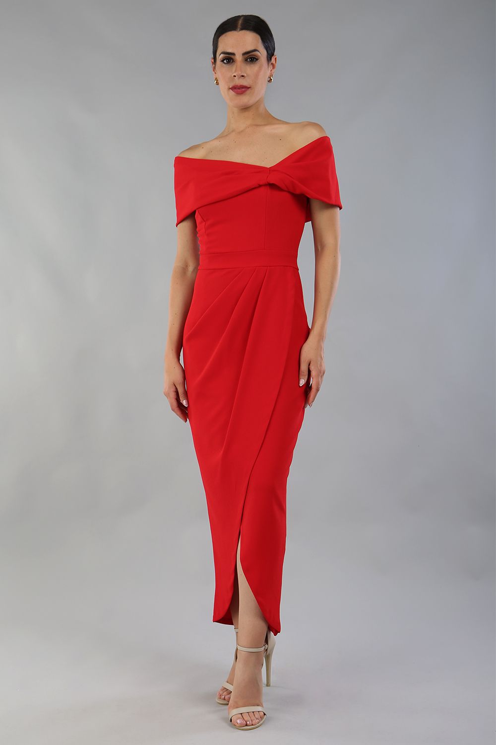 model wearing diva catwalk vegas calf length midaxi dress with wide bardot neckline and open shoulders with a large opening at the front of the skirt with pleating coming down long skirt front in scarlet red (Scarlet Red)