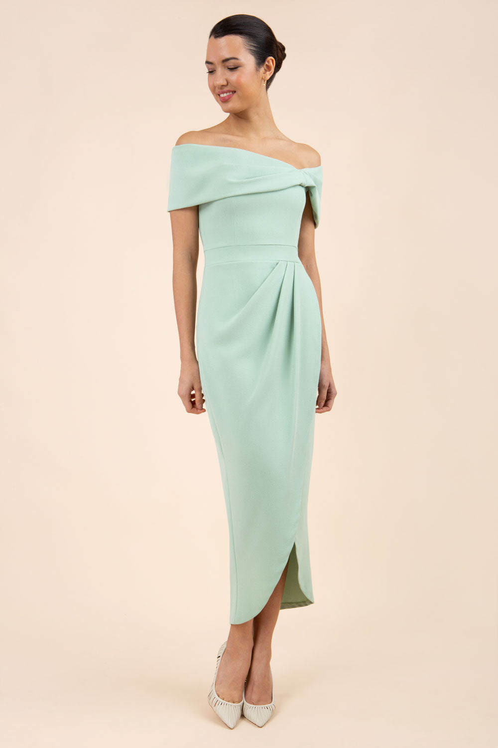 brunette model wearing diva catwalk vegas calf length pale green midaxi dress with wide bardot neckline and open shoulders with a large opening at the front of the skirt with pleating coming down long skirt front (Deco Green)