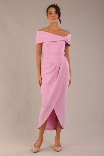 brunette model wearing diva catwalk vegas calf length dawn pink midaxi dress with wide bardot neckline and open shoulders with a large opening at the front of the skirt with pleating coming down long skirt front (Dawn Pink)