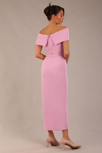 brunette model wearing diva catwalk vegas calf length dawn pink midaxi dress with wide bardot neckline and open shoulders with a large opening at the front of the skirt with pleating coming down long skirt front (Dawn Pink)