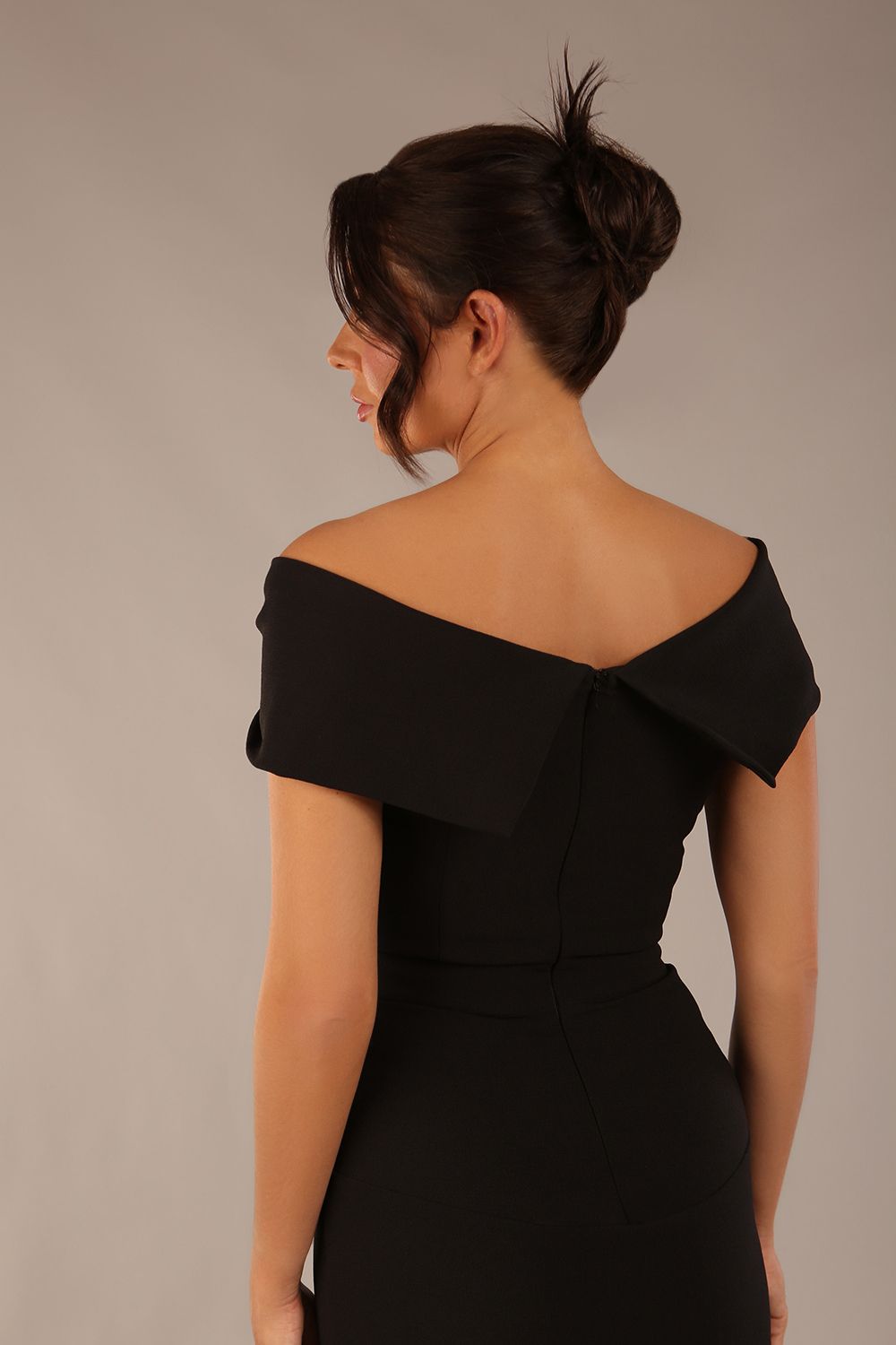 brunette model wearing diva catwalk vegas calf-length black midaxi dress with wide bardot neckline and open shoulders with a large opening at the front of the skirt with pleating coming down long skirt front (Black)