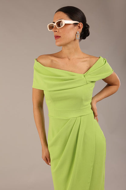 brunette model wearing diva catwalk vegas calf length lime green midaxi dress with wide bardot neckline and open shoulders with a large opening at the front of the skirt with pleating coming down long skirt front (Lime Green)