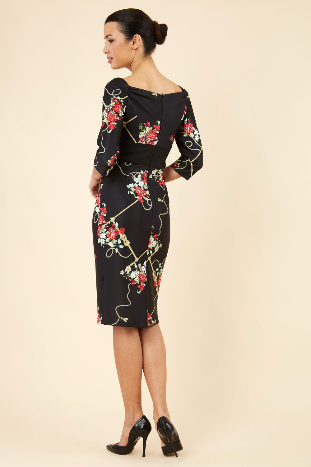 Brunette model is wearing Diva Catwalk Pencil Printed three quarter sleeved dress with wide black band and wide v neckline in Vintage Rose print front