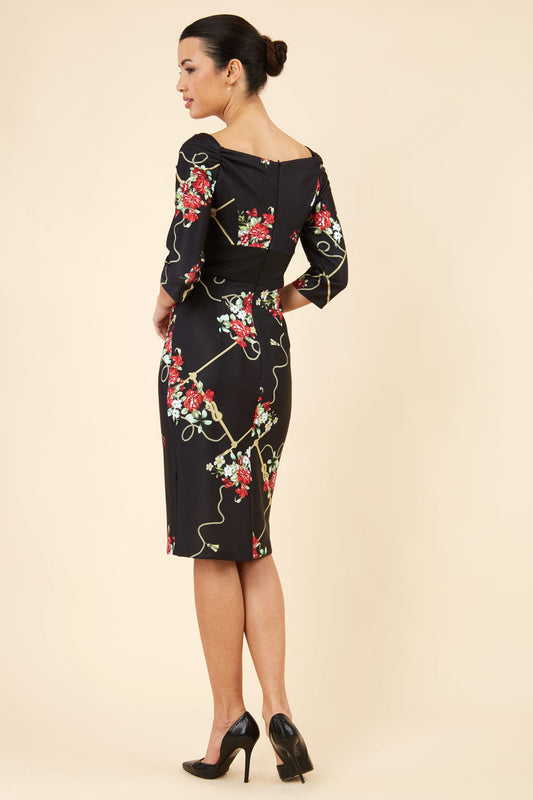 Brunette model is wearing Diva Catwalk Pencil Printed three quarter sleeved dress with wide black band and wide v neckline in Vintage Rose print front