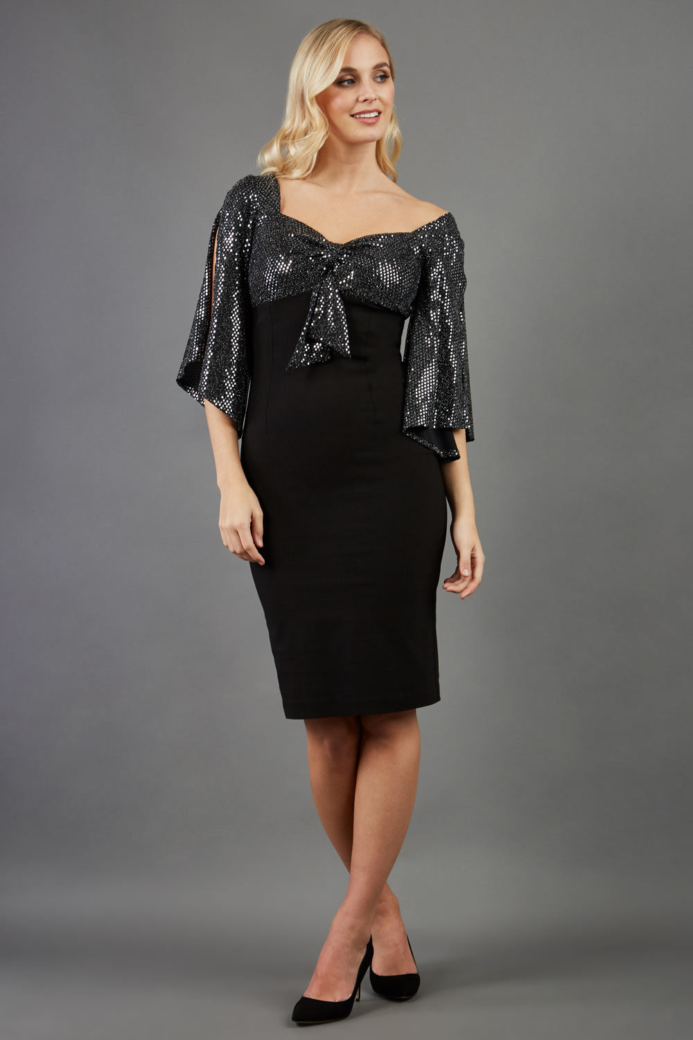 blonde model is wearing diva catwalk premiere pencil vintage sperkly dress with sleeves and empire waist in black front