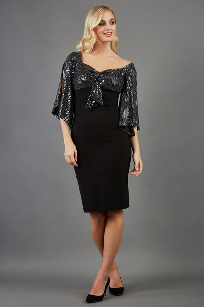blonde model is wearing diva catwalk premiere pencil vintage sperkly dress with sleeves and empire waist in black front