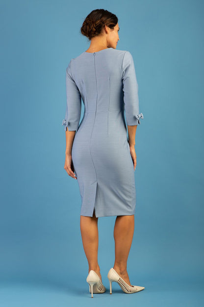 blonde model is wearing diva catwalk logan round neck sleeved pencil dress with side arrow pleating detail in steel blue front