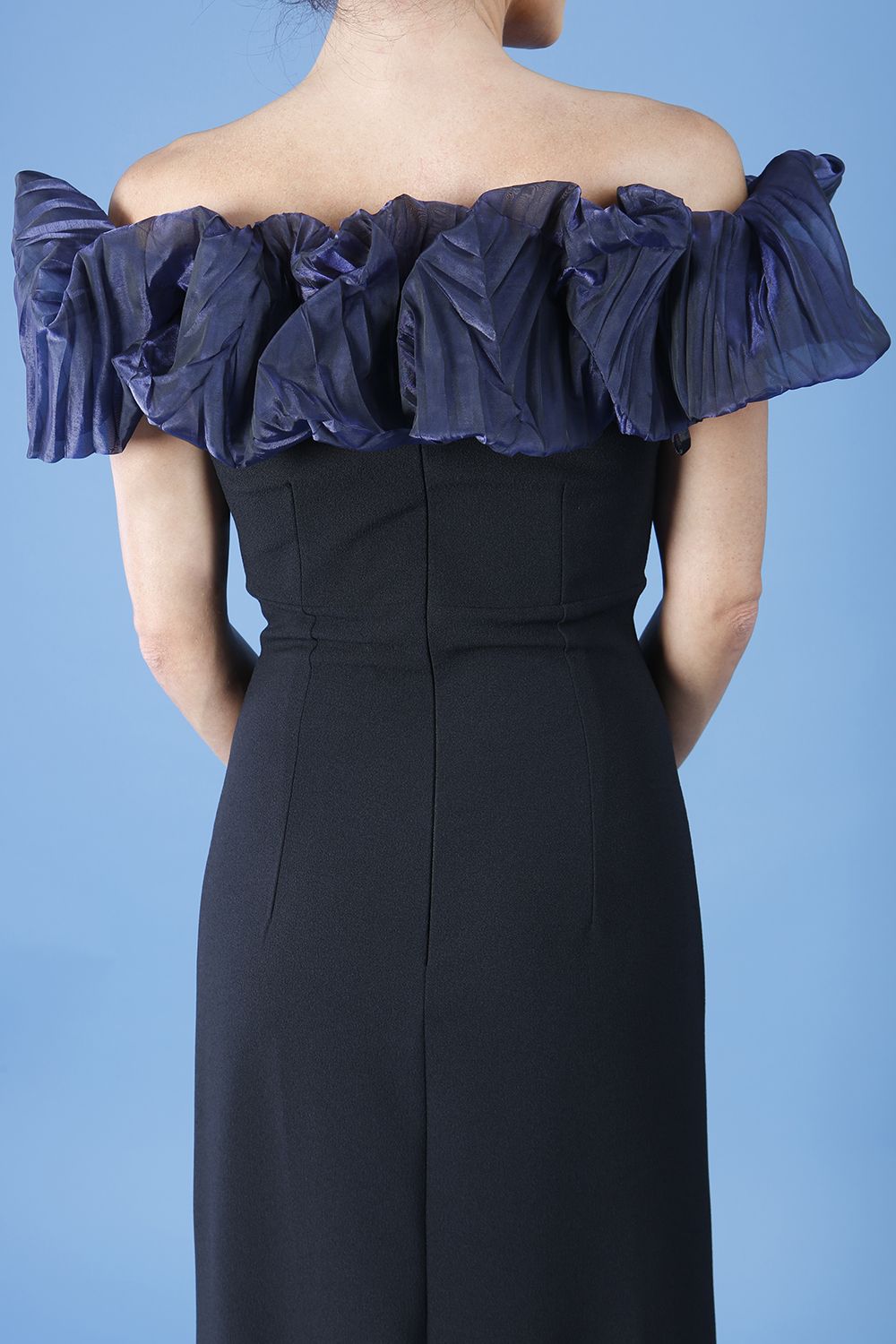 brunette model is wearing diva catwalk classique maxi black dress with off shoulder organza detail without sleeves in black and navy back