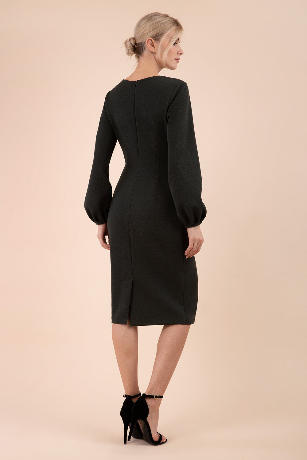 Blonde model wearing Diva Catwalk Praktica long puffed bishop sleeves knee length empire line pencil dress with round neckline with a slit cut in the middle in Black front