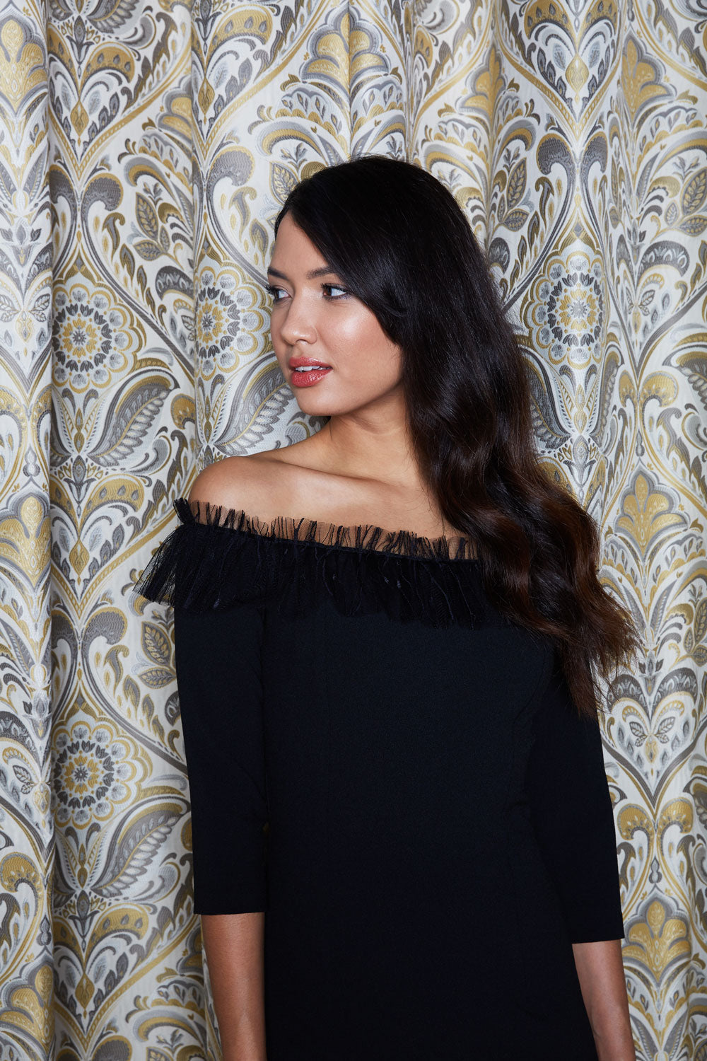 Brunette Model wearing Diva Catwalk Lyrical Pencil Knee length three quarter sleeve off-shoulder Bardot neckline Dress with lace detail around the neckline in Black front