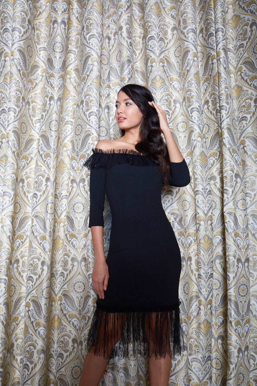 Brunette Model wearing Diva Catwalk Lyrical Pencil Knee length three quarter sleeve off-shoulder Bardot neckline Dress with lace detail around the bottom of the skirt in Black front