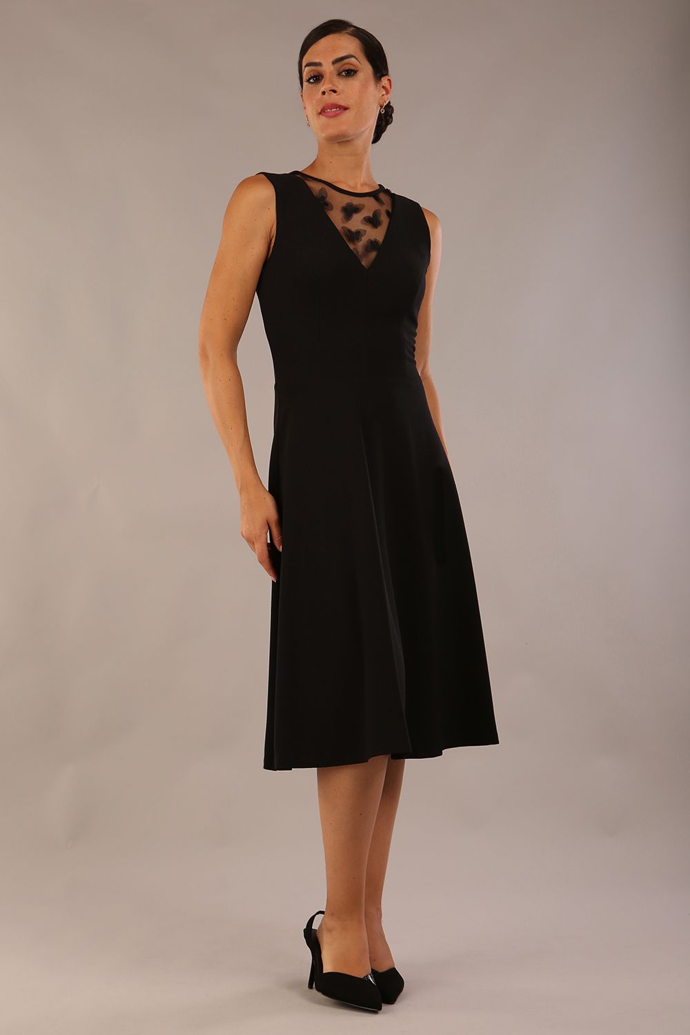 model wearing a Diva Catwalk Patina A-line Swing Sleeveless dress with v-neckline with butterfly detail in Black close up