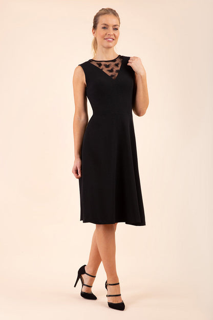 model wearing a Diva Catwalk Patina A-line Swing Sleeveless dress with v-neckline with butterfly detail in Black close up