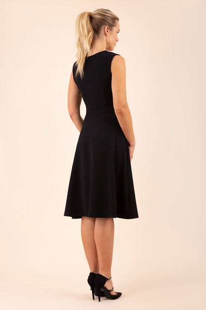 model wearing a Diva Catwalk Patina A-line Swing Sleeveless dress with v-neckline with butterfly detail in Black close up