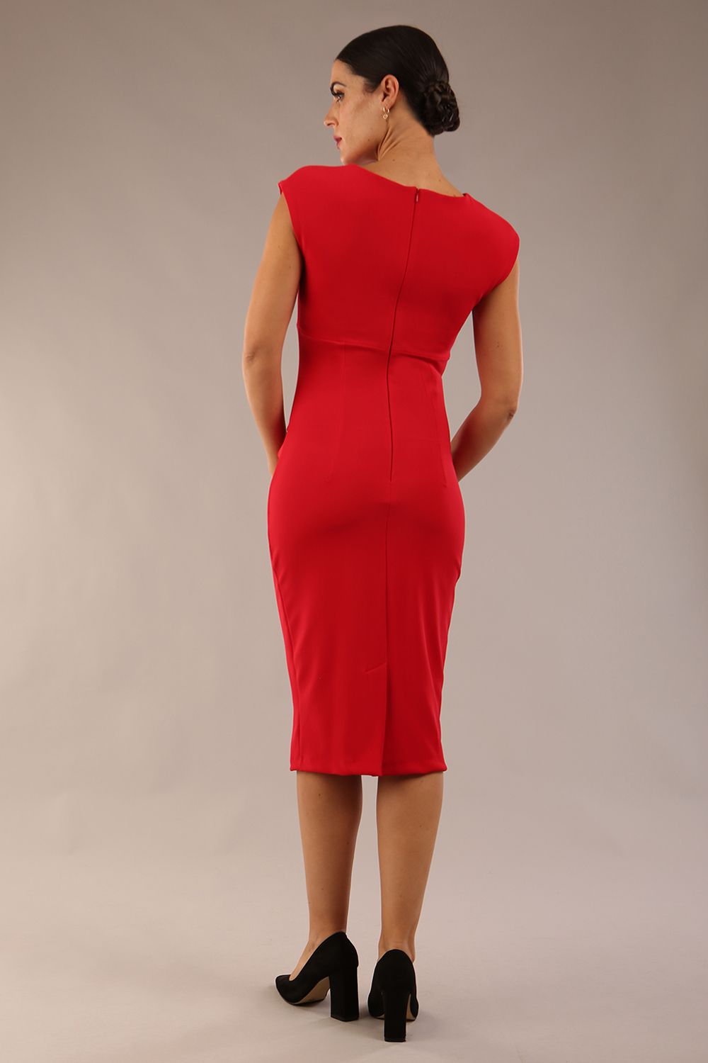 brunette model wearing diva catwalk lydia sleeveless pencil flattering fitted plain dress with split neckline and pleating across the body true red front