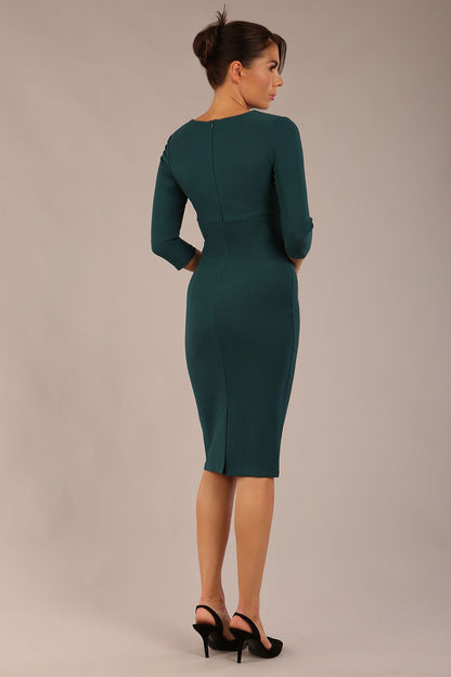 brunette model wearing a Diva Catwalk pencil three quarter sleeve dress with a split neckline and pleating across the tummy and round neck in green gables colour front
