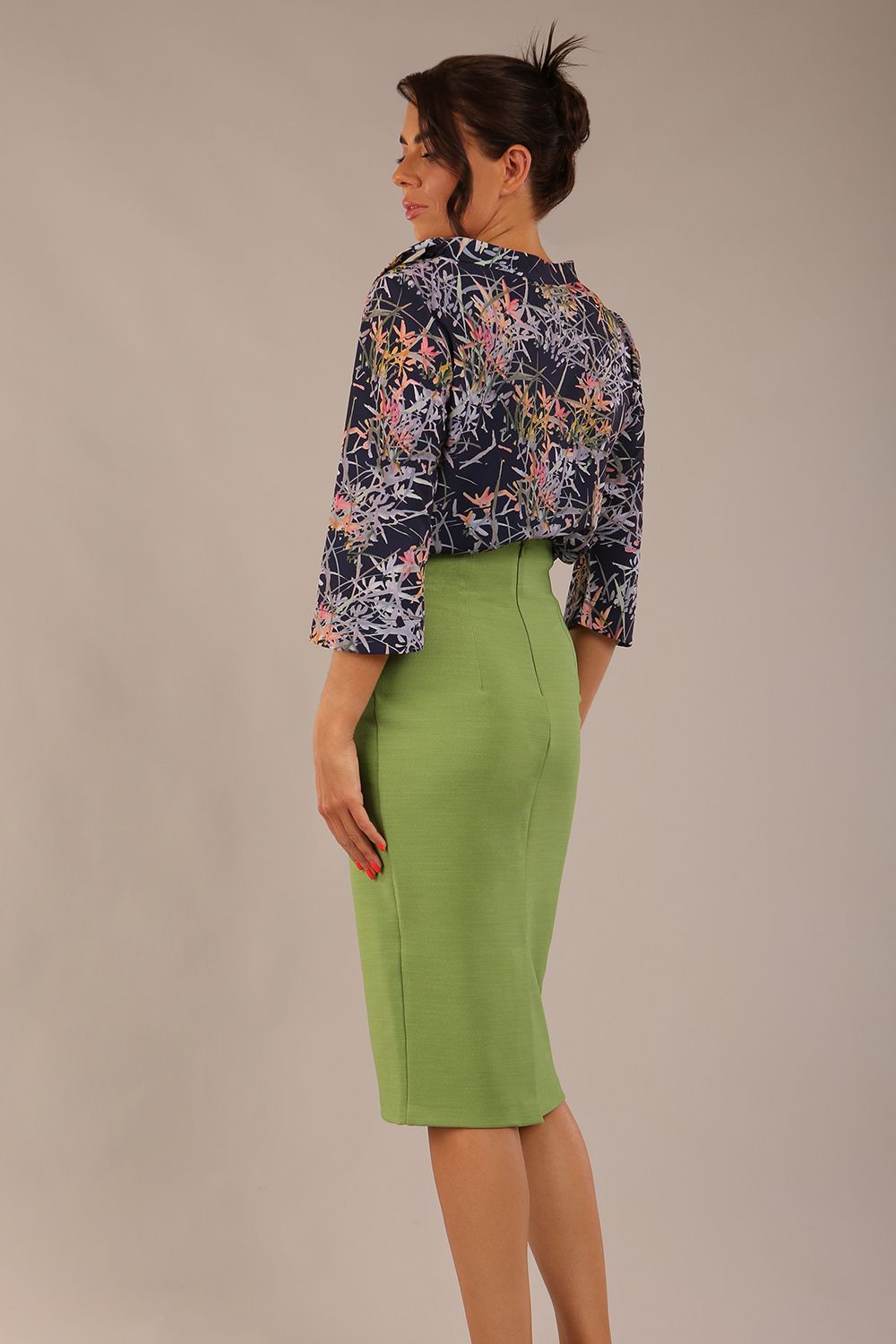 brunette model wearing a diva catwalk seed elixir pencil knee length skirt in citrus green front 