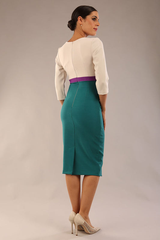 brunette model wearing seed lara pencil colour block dress three quarter sleeve and pleating across the body with split neckline in Pacific green and sandy cream and amethyst purple front