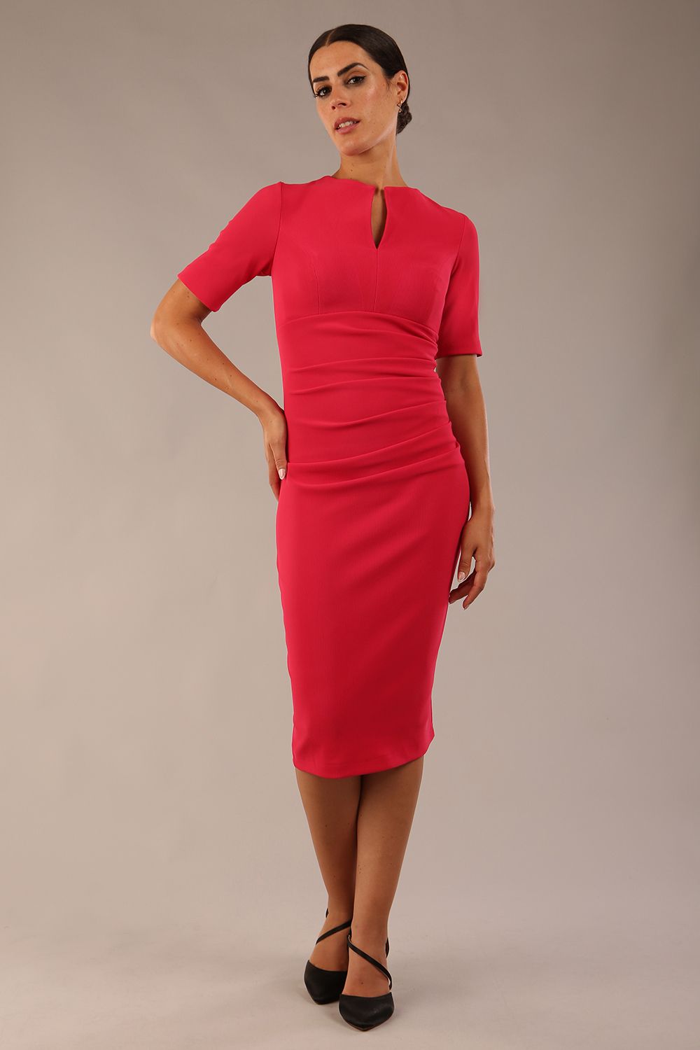 brunette model is wearing a Diva Catwalk Lydia Short Sleeve Pencil Dress with pleating across the tummy and split neckline in Raspberry Pink colour front