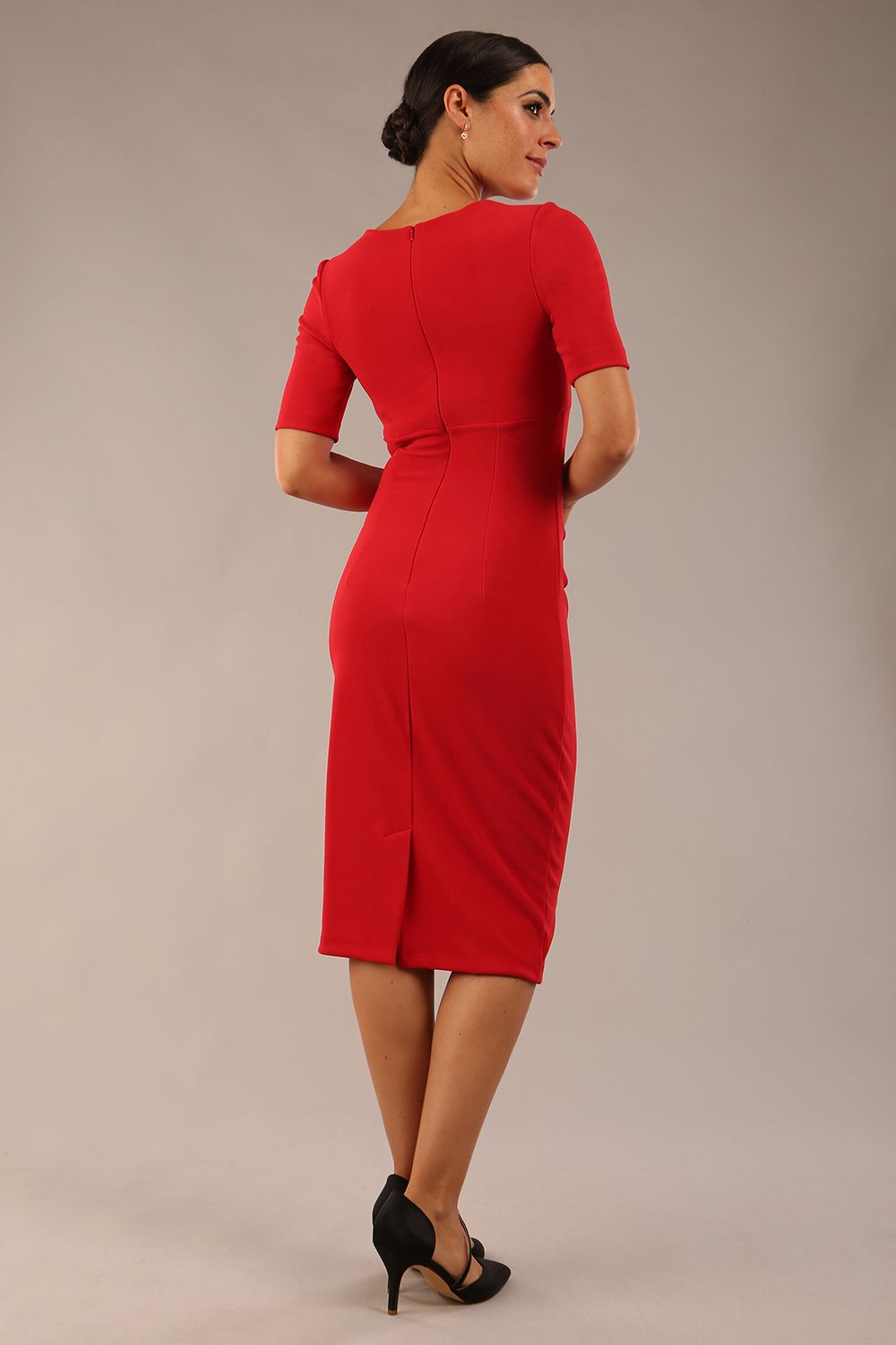 brunette model is wearing a Diva Catwalk Lydia Short Sleeve Pencil Dress with pleating across the tummy and split neckline in True Red colour front