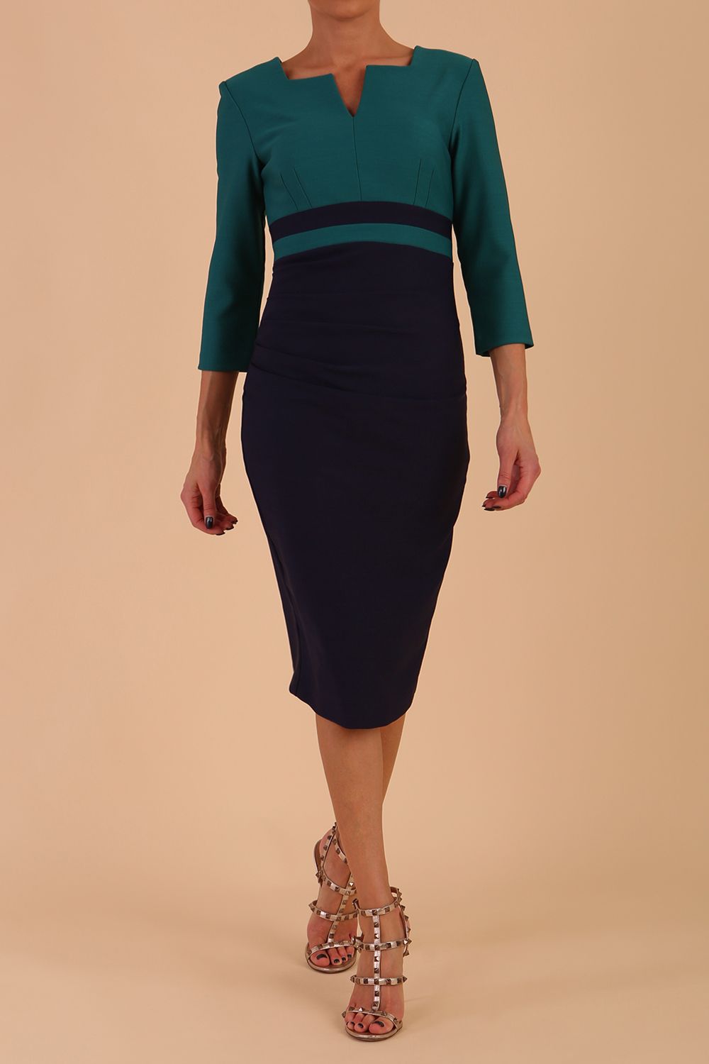 A model is wearing a three quarter sleeve colour block pencil dress by Diva Catwalk in navy and green colour