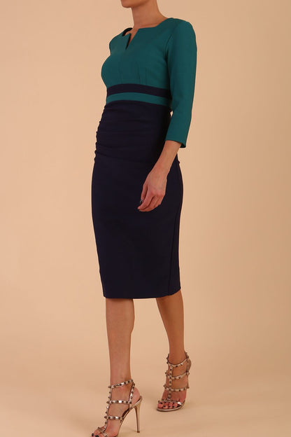 A model is wearing a three quarter sleeve colour block pencil dress by Diva Catwalk in navy and green colour