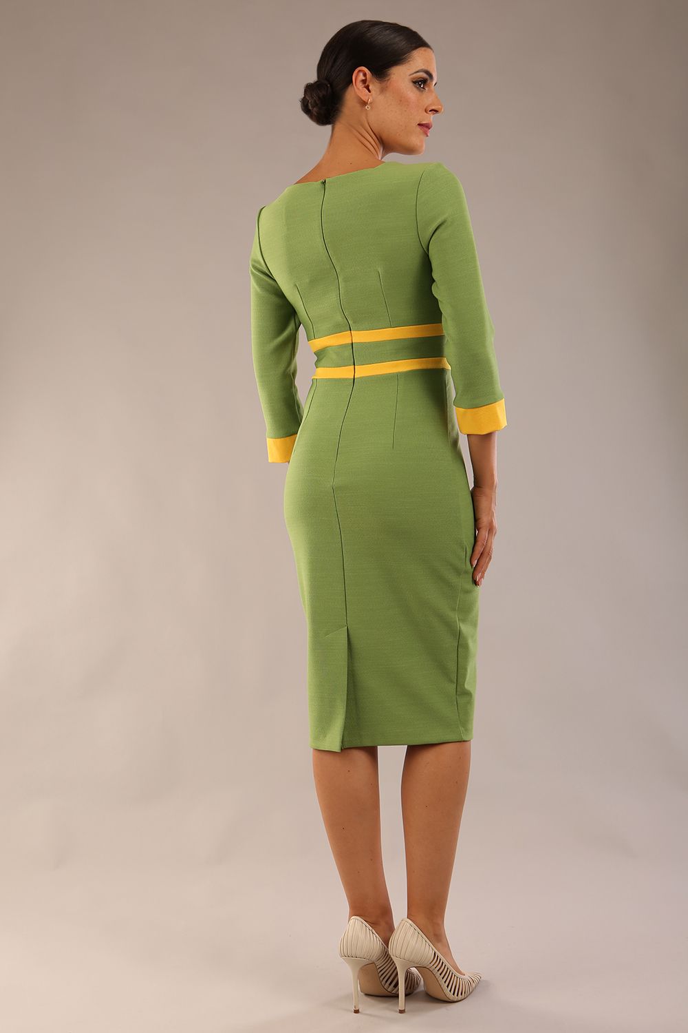 Model wearing Diva catwalk Paeonia dress square neckline with a vent in Citrus Green with Daffodil Yellow and Citrus Green stripes around the waist and three quarter sleeve with Daffodil Yellow contrast finish front close up