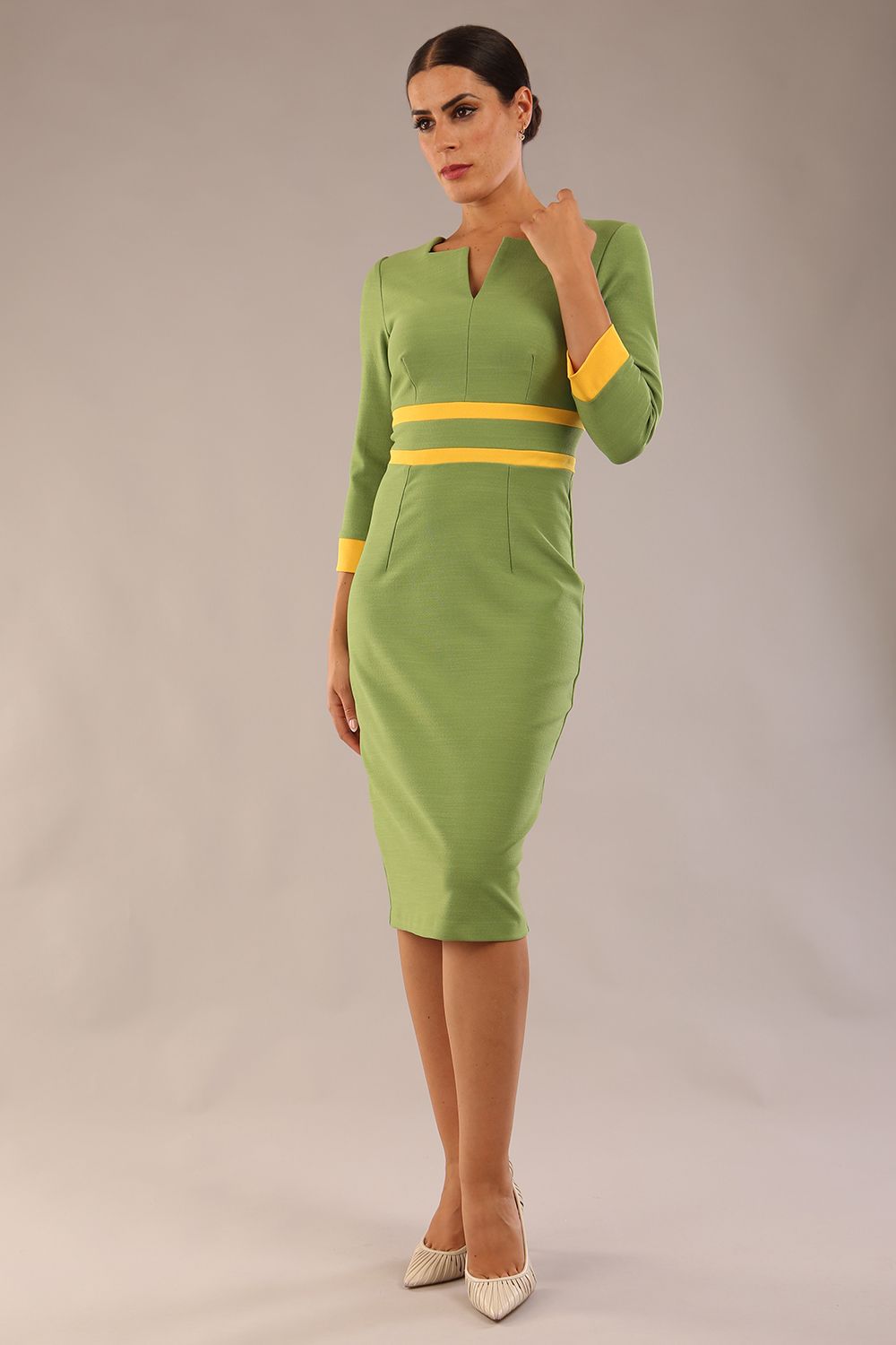 Model wearing Diva catwalk Paeonia dress square neckline with a vent in Citrus Green with Daffodil Yellow and Citrus Green stripes around the waist and three quarter sleeve with Daffodil Yellow contrast finish front close up