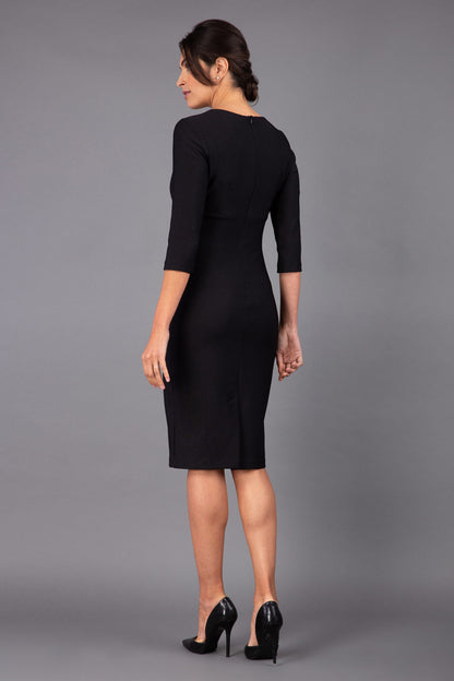 Model wearing Diva catwalk Minette dress in black with three quarter sleeve figure fitted pencil dress front image
