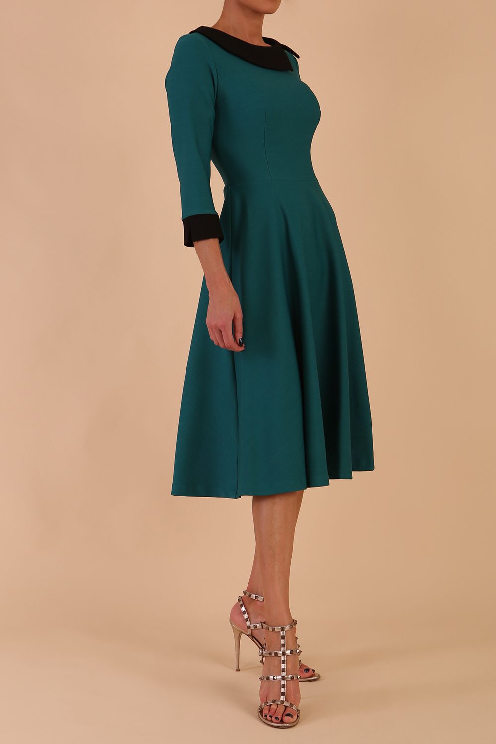 Model wearing Diva catwalk Coralia swing dress in pacific green with three quarter sleeve figure fitted front image