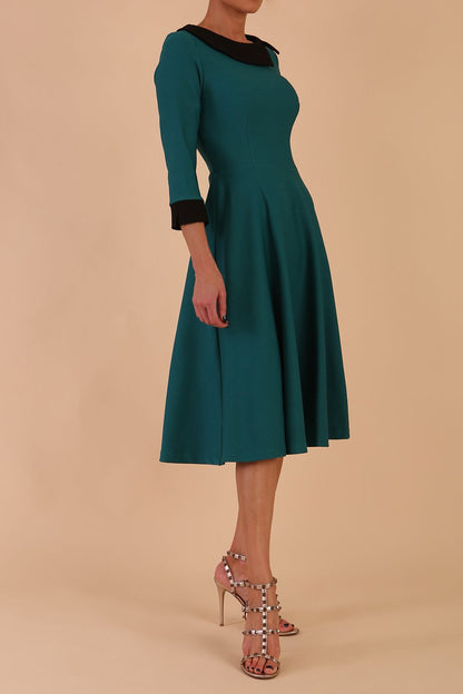 Model wearing Diva catwalk Coralia swing dress in pacific green with three quarter sleeve figure fitted front image