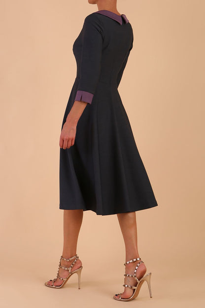 Model wearing Diva catwalk Coralia swing dress in slate grey/ lilac with three quarter sleeve figure fitted front image