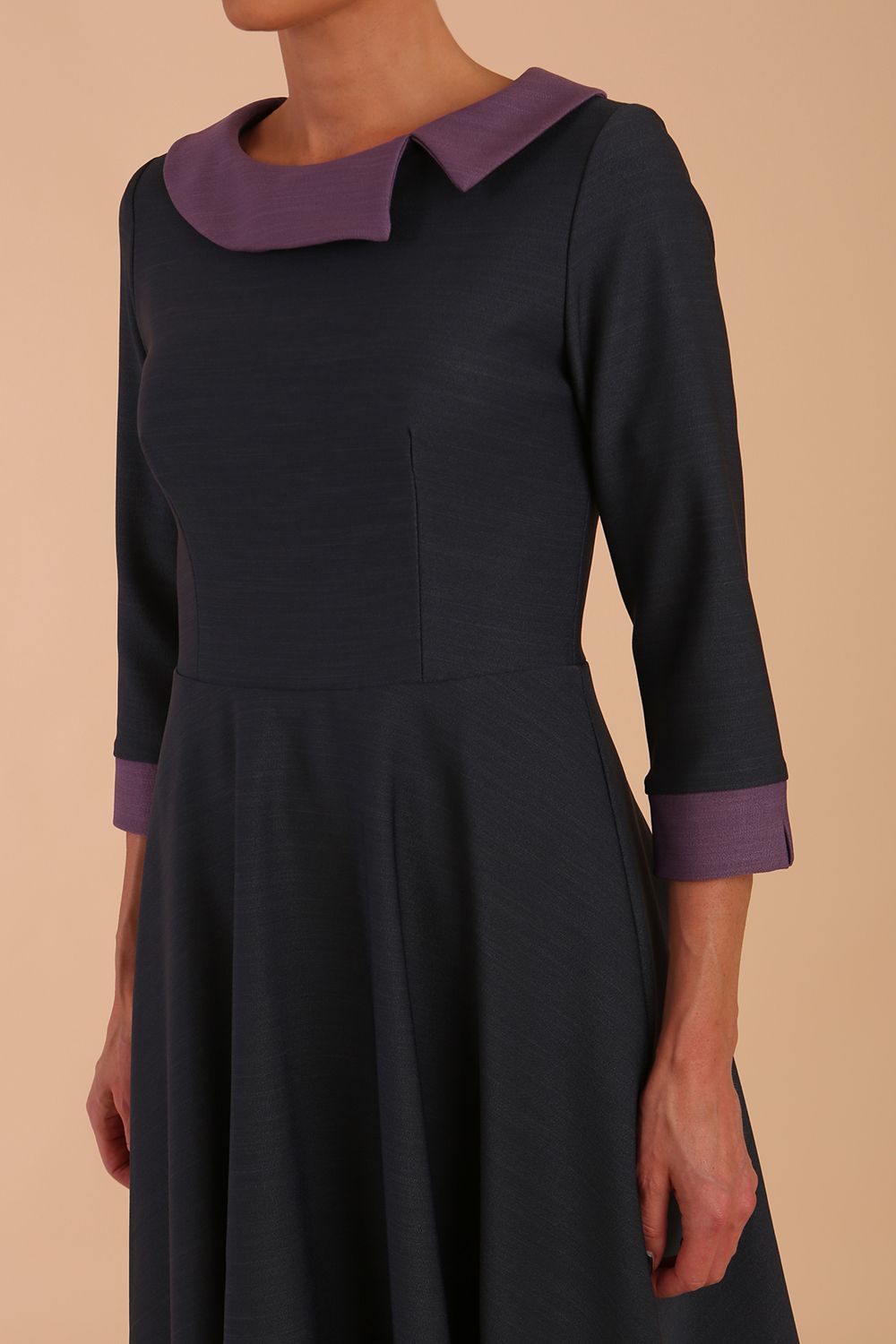 Model wearing Diva catwalk Coralia swing dress in slate grey/ lilac with three quarter sleeve figure fitted front image
