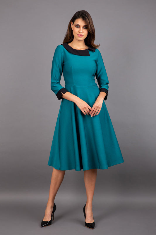 Model wearing Diva catwalk Coralia swing dress in pacific green with three quarter sleeve figure fitted front image