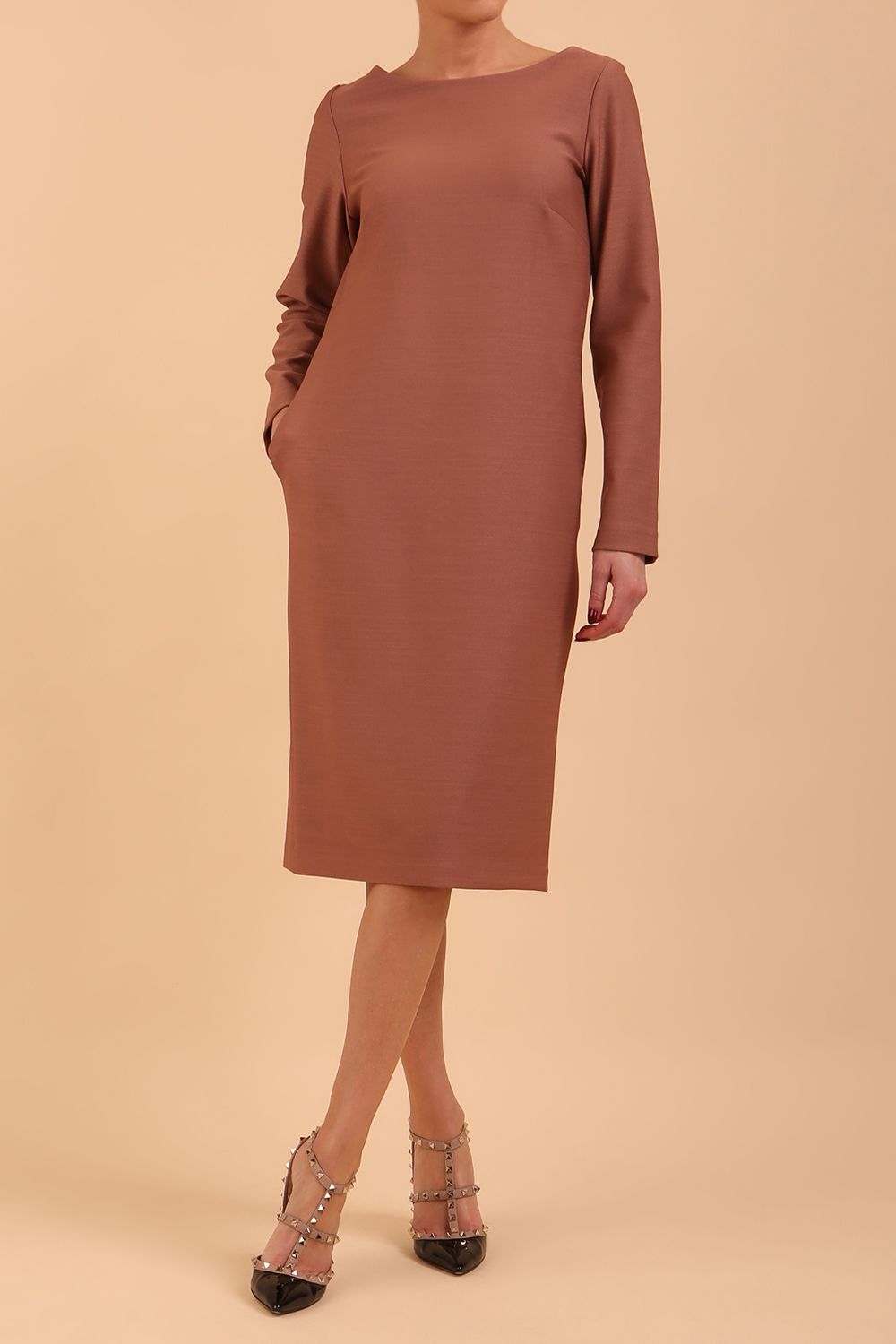 brunette model wearing diva catwalk cora white pencil dress with long sleeves and rounded neckline with pockets in colour acorn brown on  front