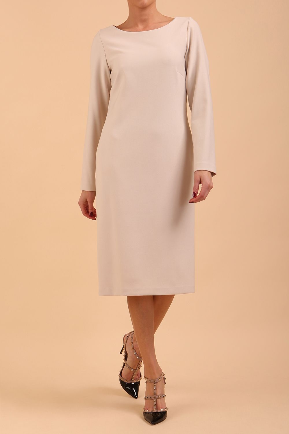 brunette model wearing diva catwalk cora white pencil dress with long sleeves and rounded neckline with pockets in colour sandy cream on side front