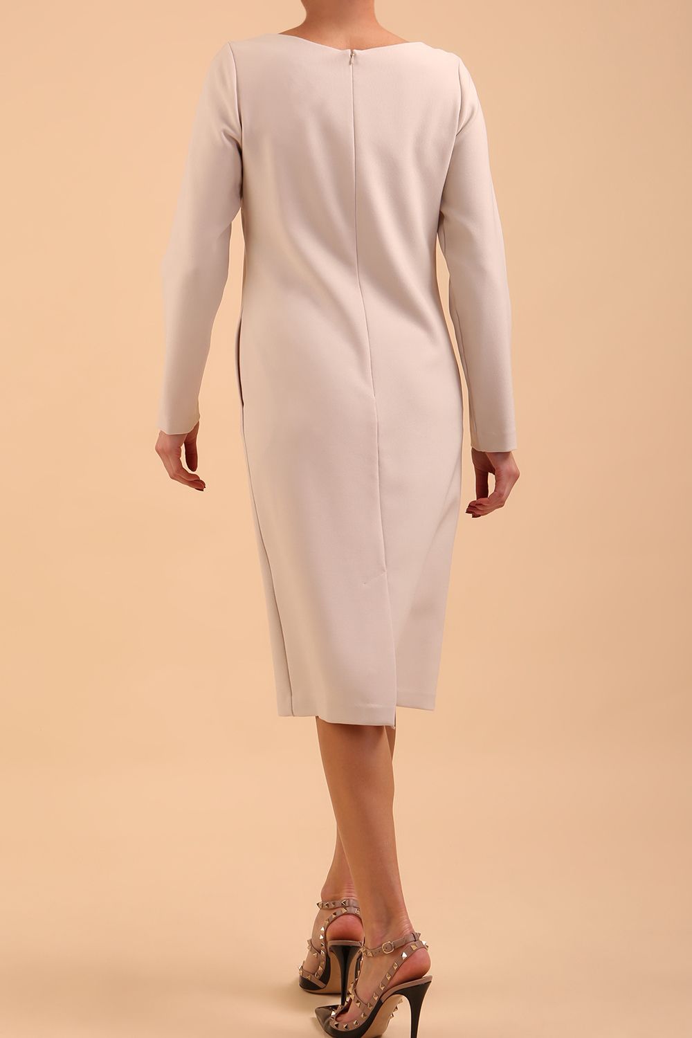 brunette model wearing diva catwalk cora white pencil dress with long sleeves and rounded neckline with pockets in colour sandy cream on side front