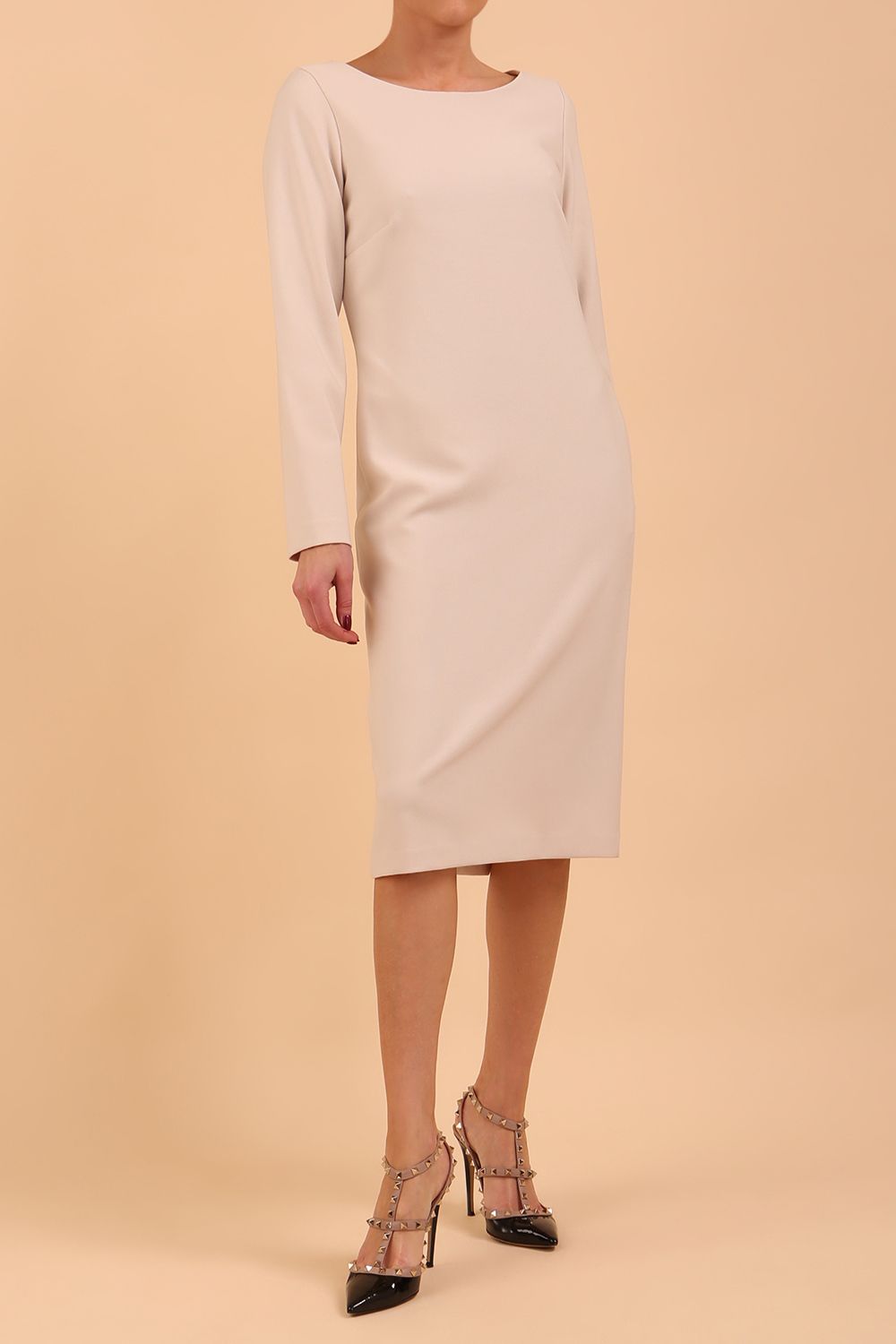 brunette model wearing diva catwalk cora white pencil dress with long sleeves and rounded neckline with pockets in colour sandy cream on side front