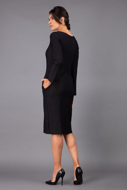 brunette model wearing diva catwalk cora white pencil dress with long sleeves and rounded neckline with pockets in colour black on side front
